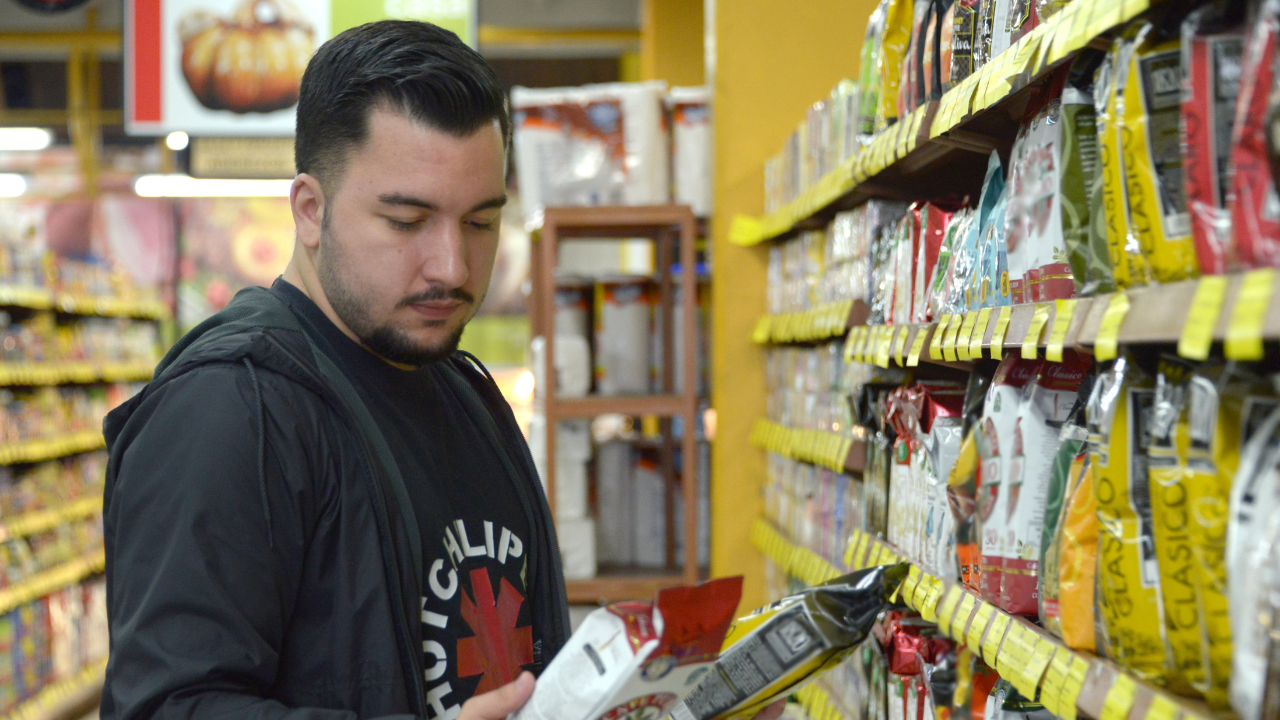 Joven comparando productos en un supermercado